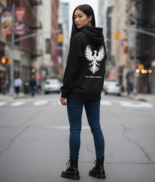 Person wearing a black hoodie with a white phoenix design on a city street. Stray Kids lyric